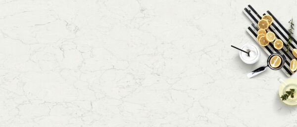 Close-up detail of Calacatta Aidana white quartz showcasing soft gray cracked veins and a polished finish.