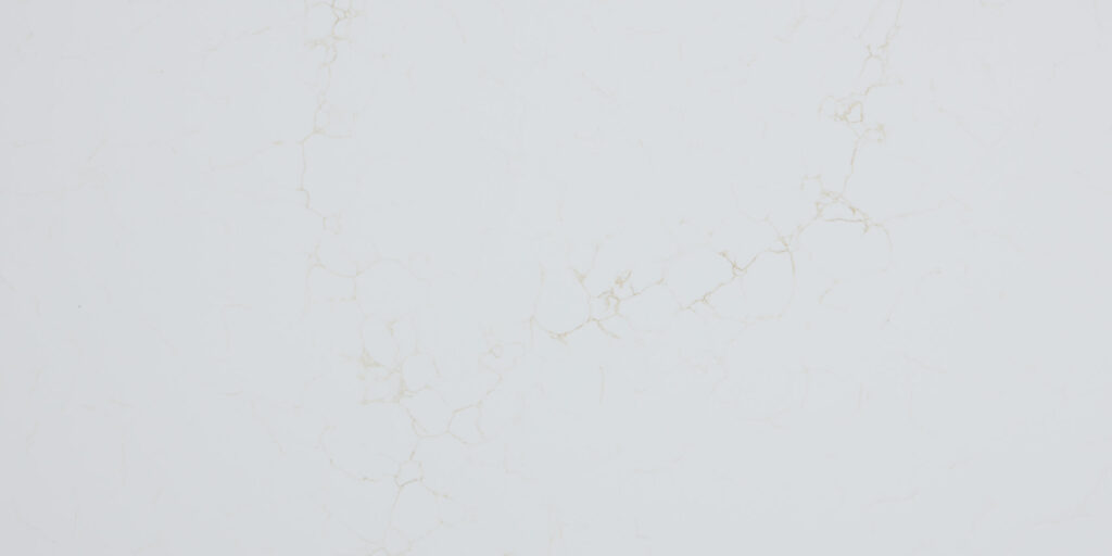 Calacatta Mysterio Gold IR Jumbo Quartz by Venezia Surfaces, a white quartz surface with soft warm gold veining.