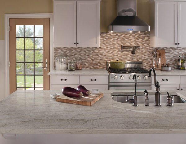 Sea Pearl quartzite island and backsplash in a light kitchen