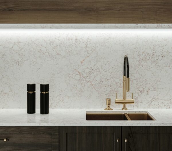 Riviére Rose Silestone countertop and backsplash with a brass faucet