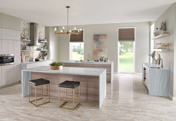 White Macaubas quartzite island in a bright kitchen with light cabinets